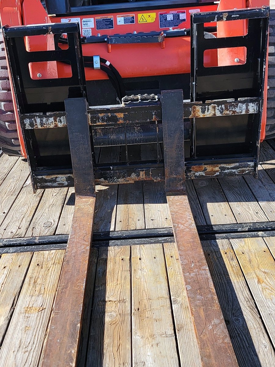 4 ft manual skid steer pallet forks mounted on a Kubota SSV75