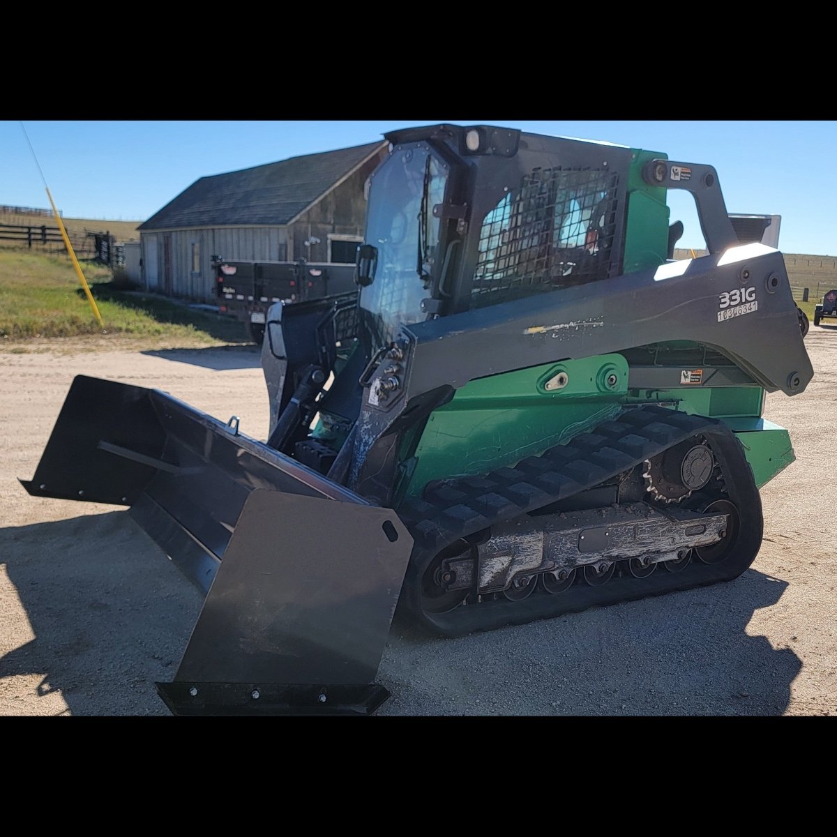 John Deere 331G compact track loader with 108-inch snow pusher, front three-quarter view
